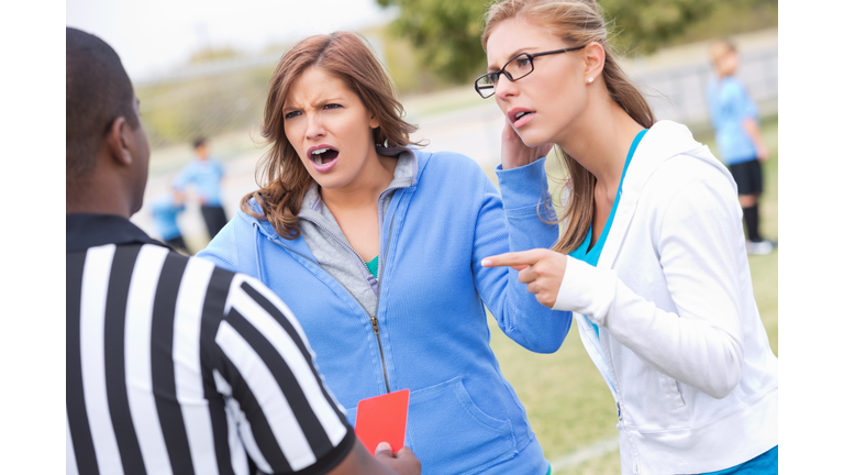 Angry soccer moms yelling at referee during kids' game