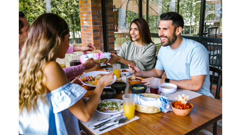 Group of latin friends eating mexican food in the restaurant terrace in Mexico Latin America