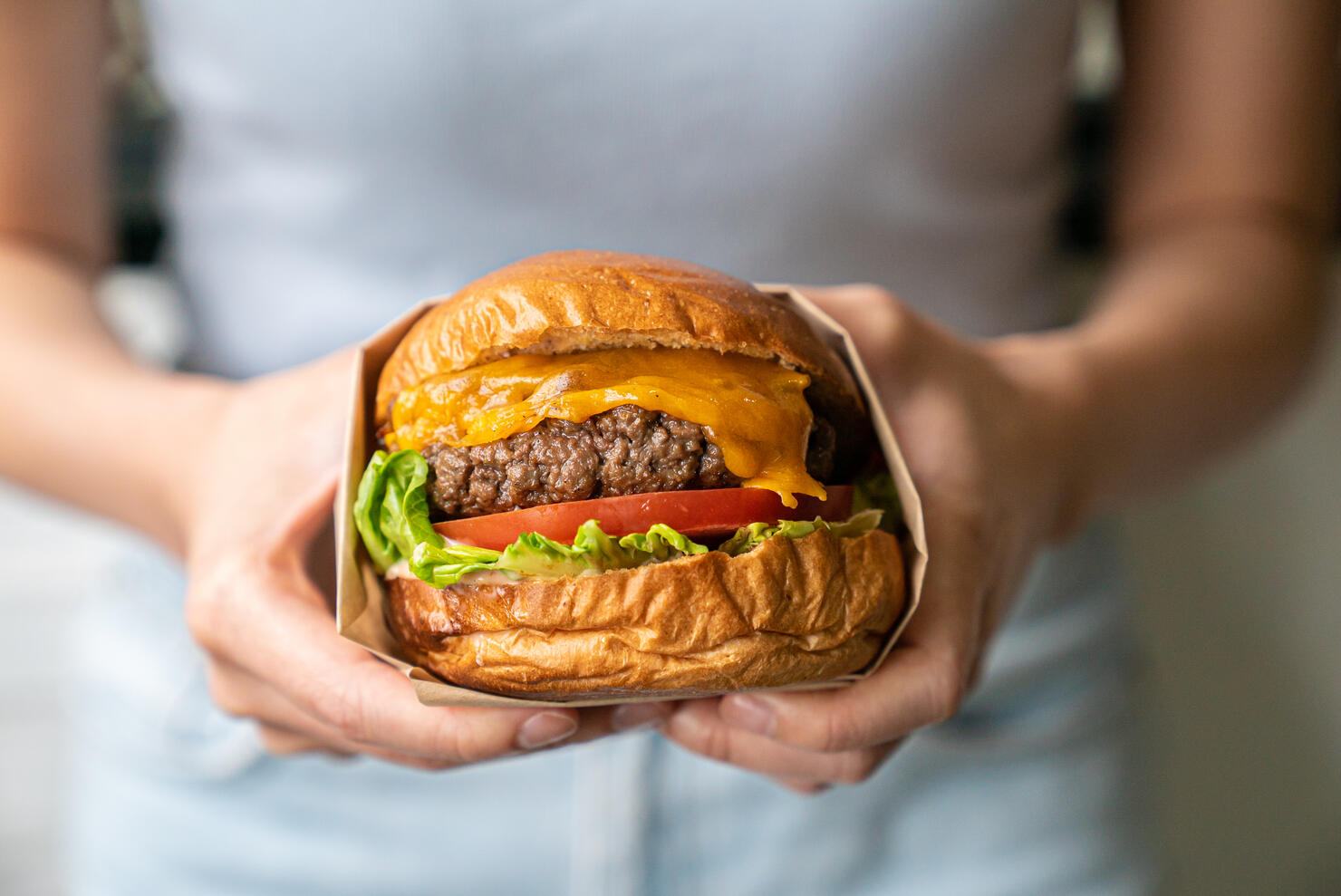 Midsection of woman holding burger