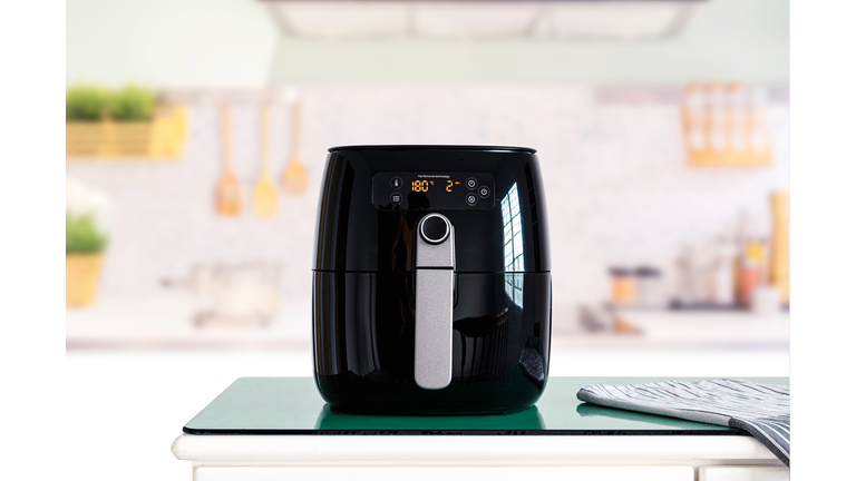 Air fryer machine cooking potato fried in kitchen.  Lifestyle of new normal cooking.