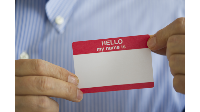 Jersey City, New Jersey, Close up of businessman's hands holding  blank name tag, studio shot