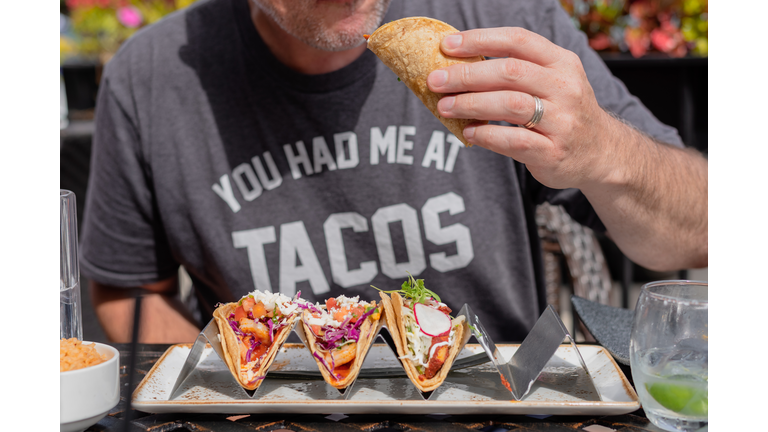 Midsection Of Man Eating Tacos