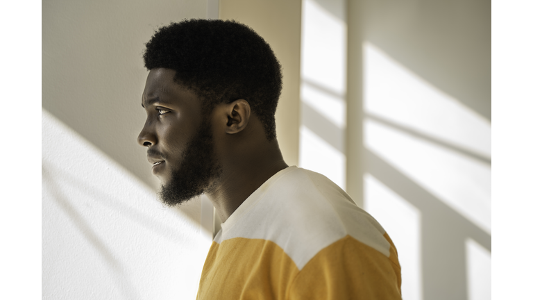 Side portrait of a young and handsome African American black man looking at the window