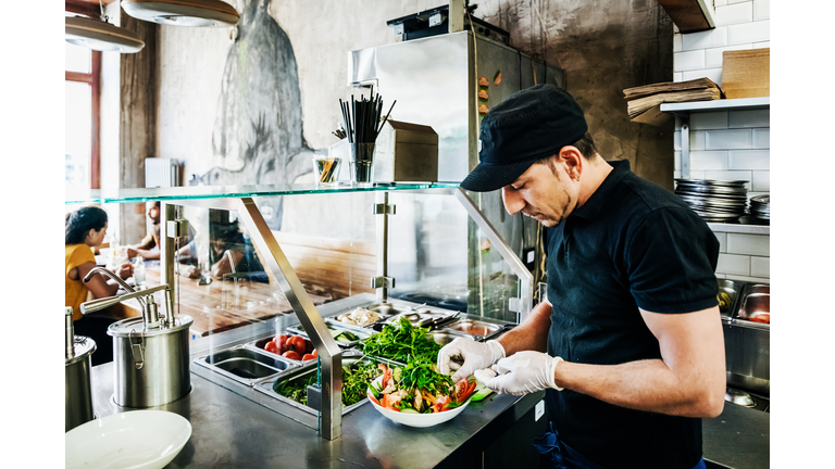 Chef Preparing Salad Dish For Customer