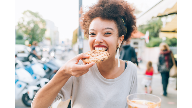 Young woman eating cookie at outdoor cafe