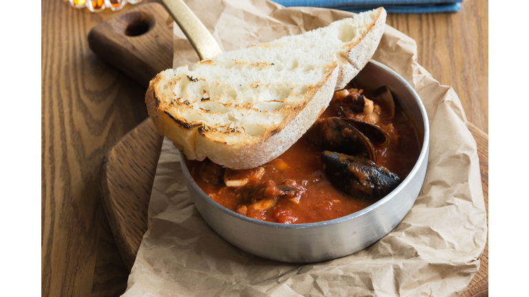 Delicious hearty lunch at a fish restaurant. Tuscan tomato soup with seafood Cacciucca.