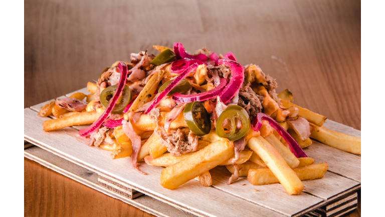Loaded french fries with pulled pork, jalapenos, cheddar sauce and onion