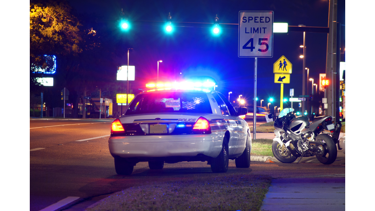 Police traffic stop at night with motorcycle pulled over