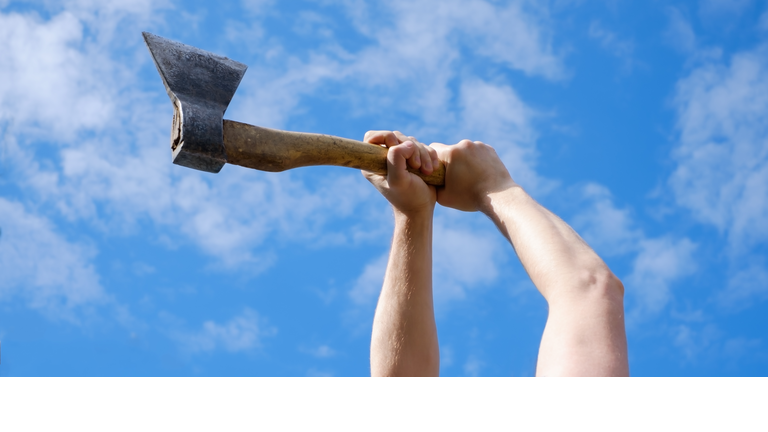 Hands of man choping firewood with axe on blue sky
