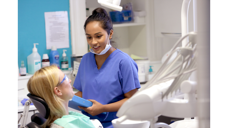 Dentist talking to patient in chair