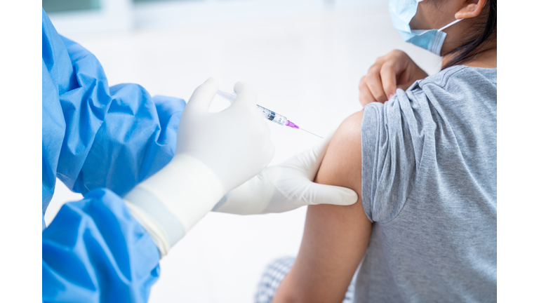 Doctor making a vaccination in the shoulder of patient teens girls person, Flu Vaccination Injection on Arm, coronavirus,covid-19 vaccine disease preparing for human clinical trials vaccination shot