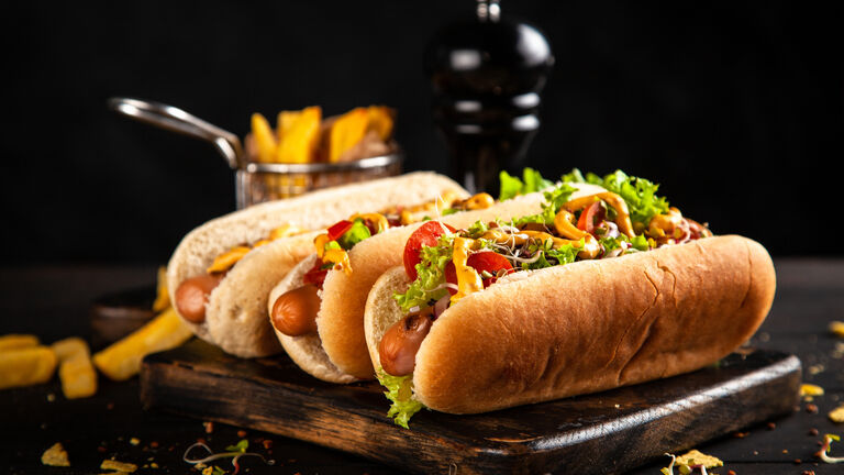 Close-up of burgers on serving board against black background