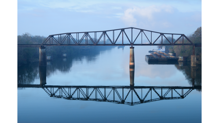 Railroad bridge over river on foggy morning