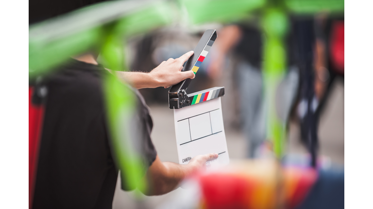 Man holding a clapperboard in front of the camera