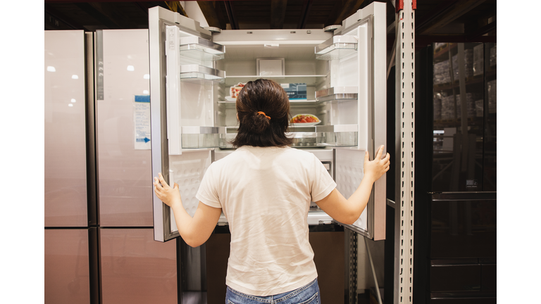 Asian woman shopping for refrigerator