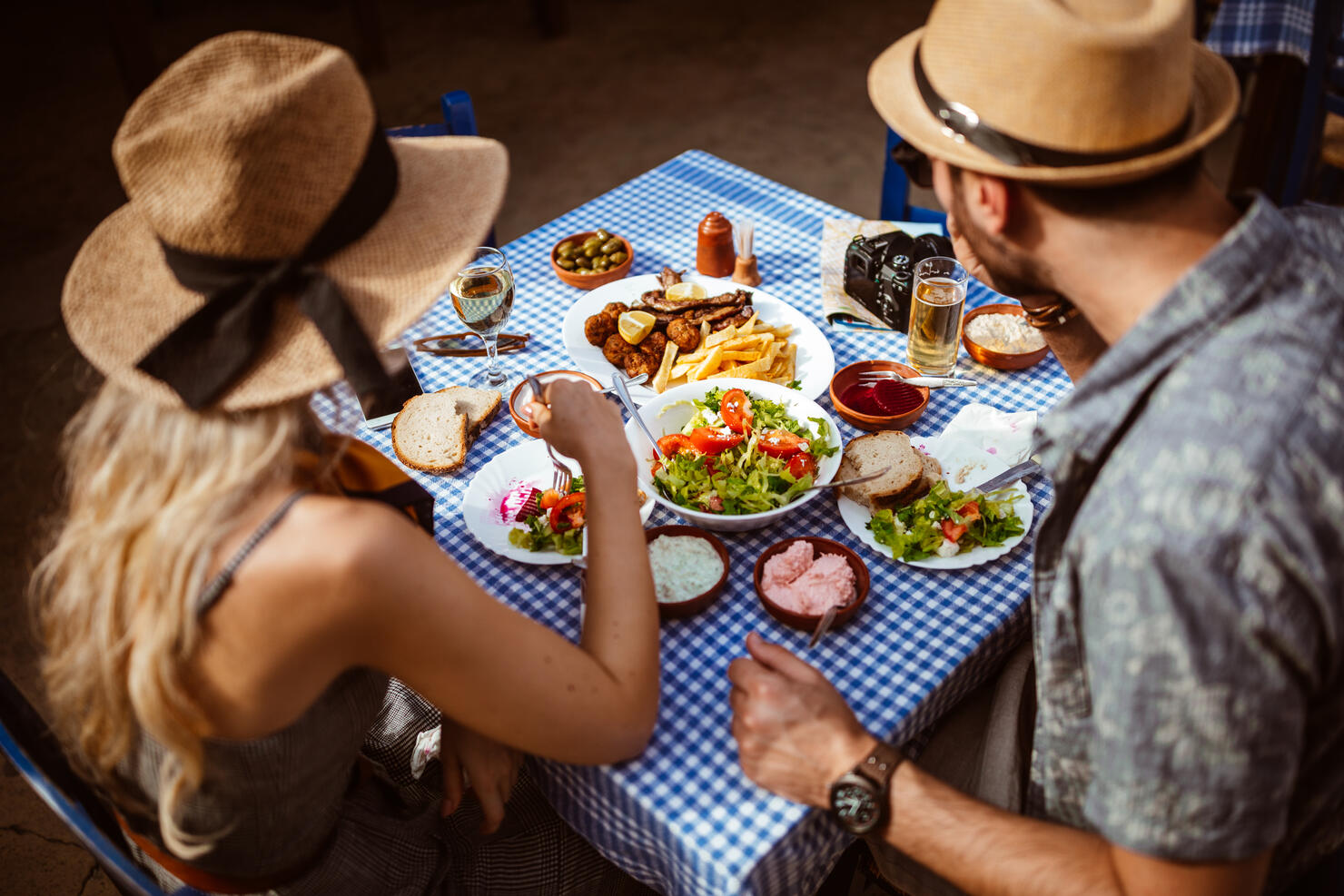 Young tourists couple eating traditional Greek food at rustic restaurant