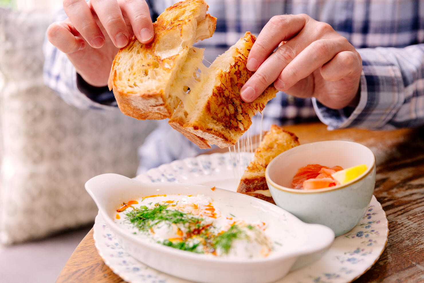 Man eating grilled cheese sandwich in a cafe for breakfast