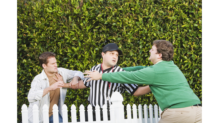 Hispanic referee between arguing neighbors