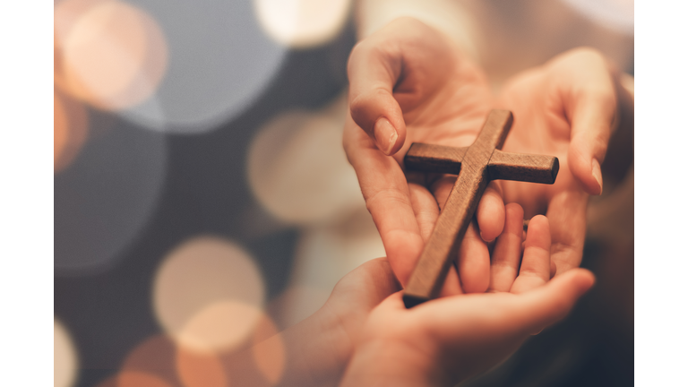 Woman's hand with cross .Concept of hope, faith, christianity, religion, church online.