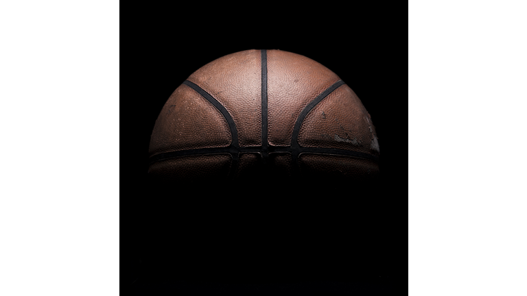 Old used basketball on black