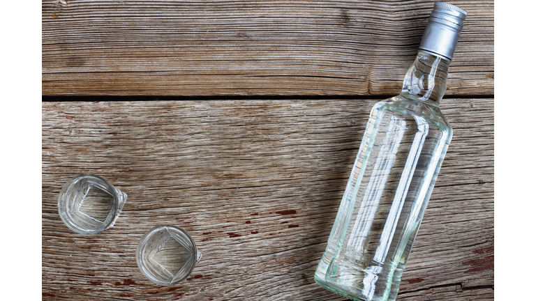 VODKA luxury. Vodka bottle with shot glasses on the Board. On wooden background.