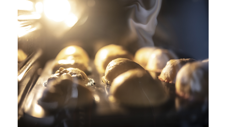 Woman preparing muffins and putting it into oven