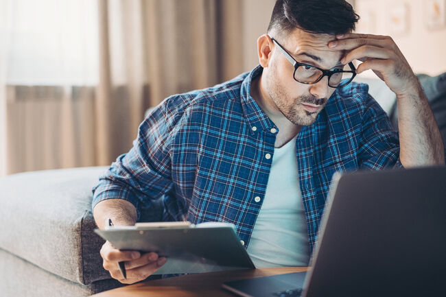 Confused young man working at home