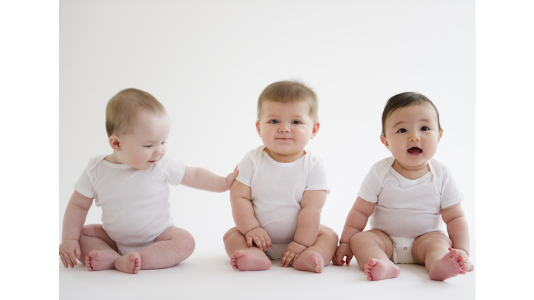 Three babies sitting on floor