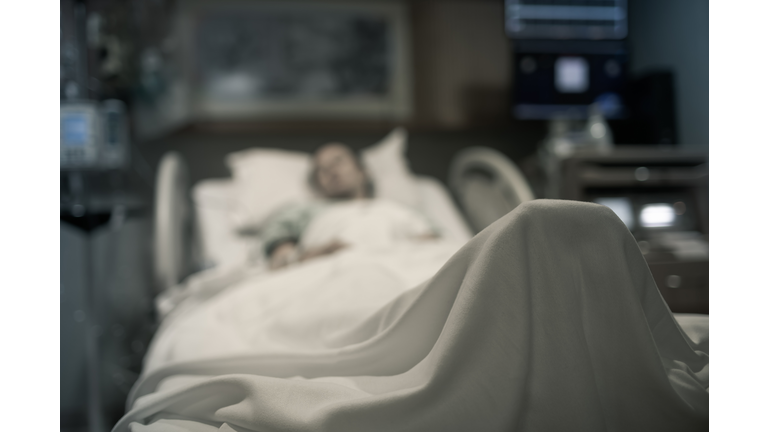 Stressed sick woman lying in hospital bed getting medical treatment.