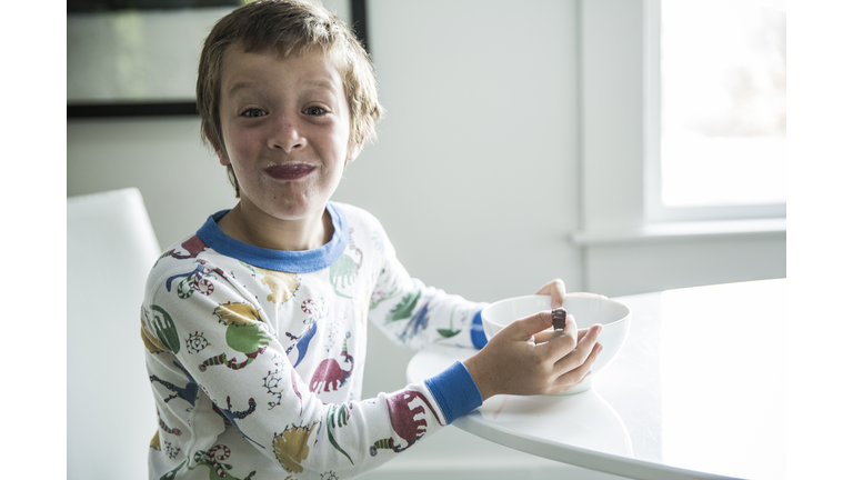 Boy in pajamas eating cereal