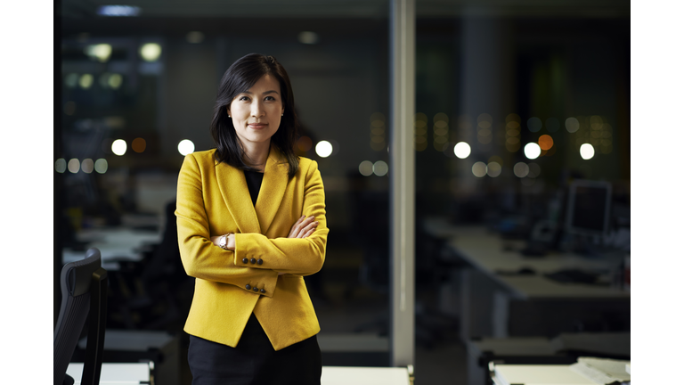 Woman standing in office at night