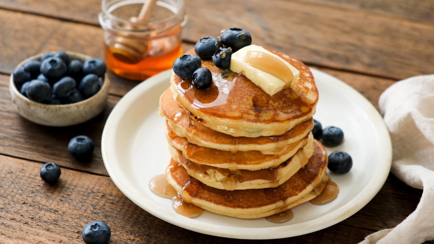 Breakfast pancakes with blueberries, butter and honey
