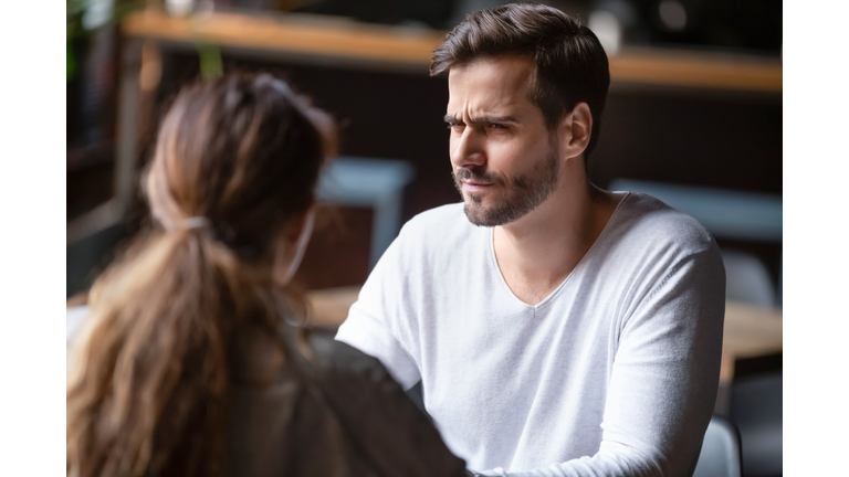 Doubting dissatisfied man looking at woman, bad first date concept