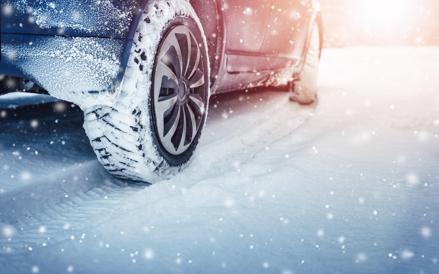 Car tires on winter road covered with snow