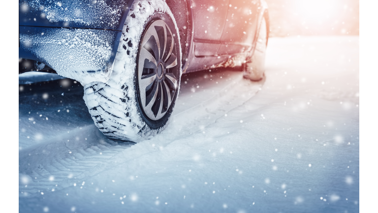 Car tires on winter road covered with snow