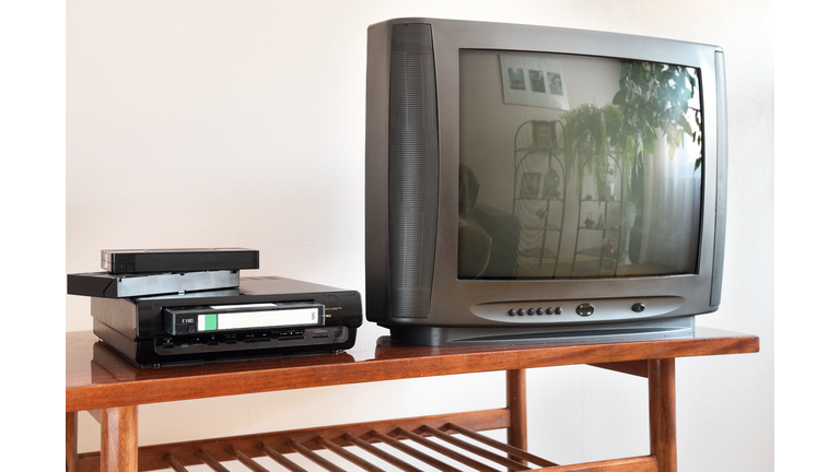 Old TV with VCR on the background of wallpaper.Retro technology concept.