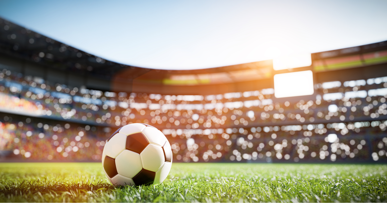 Football soccer ball on grass field on stadium