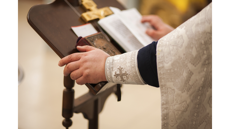 Hands of priest on pulpit