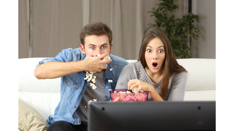 Amazed couple watching tv