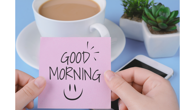 Paper card with text "good morning", cup of coffe and phone