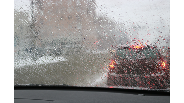 View from the car windscreen during rain and wet snow. Poor visibility while driving around the city. Snowy road.