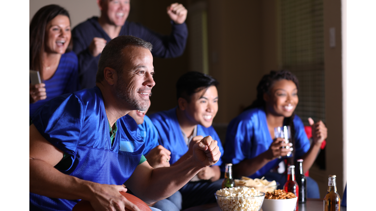 Football fans watching the game at home on television.