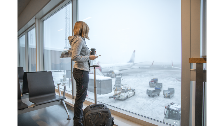 Woman standing close to window at airport