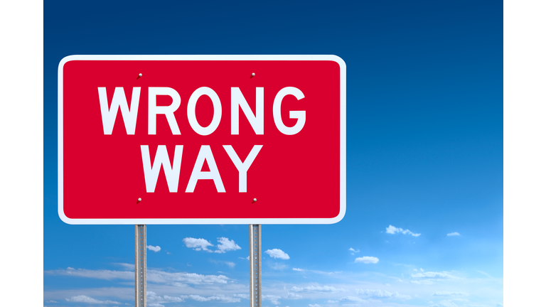 Red and White Wrong Way Road Sign Post Over Sky