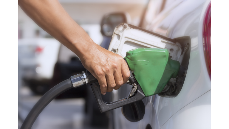 Handholds Fuel nozzle to add fuel in the car at the gas station. Close up of fuel monitoring system