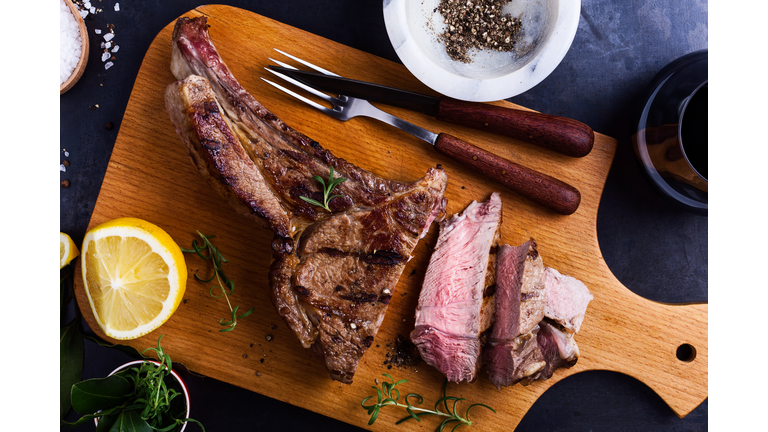 Barbecue bone-in ribeye steak on cutting board ready to eat, top view