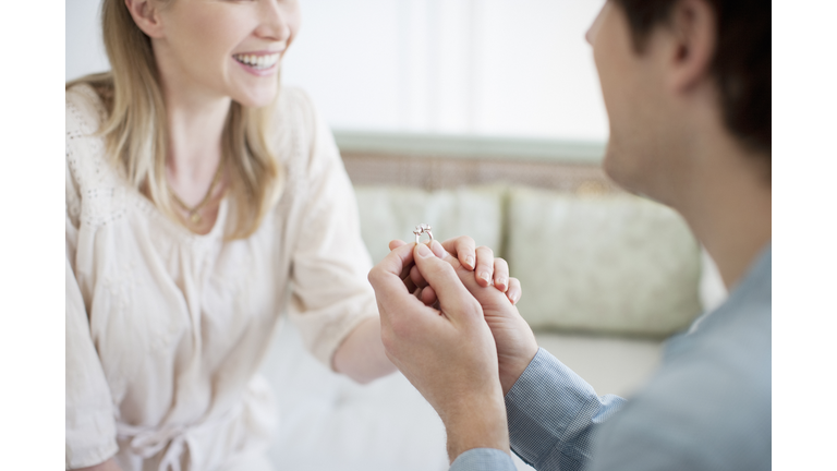 Man with engagement ring proposing marriage to woman