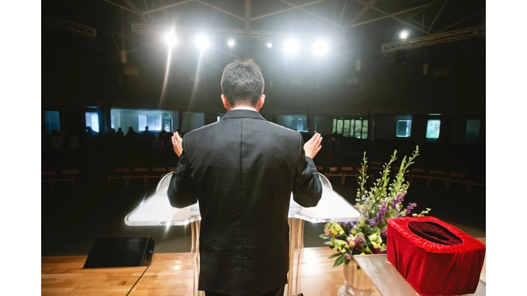Pastor praying for congregation