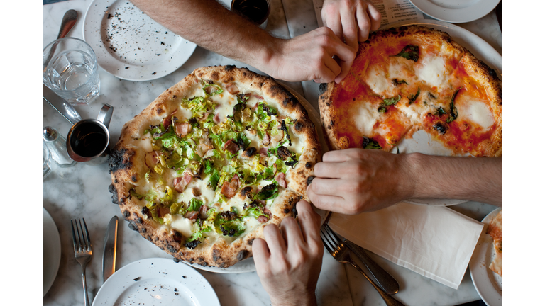 Hands Reach for Naples-Style Pizza
