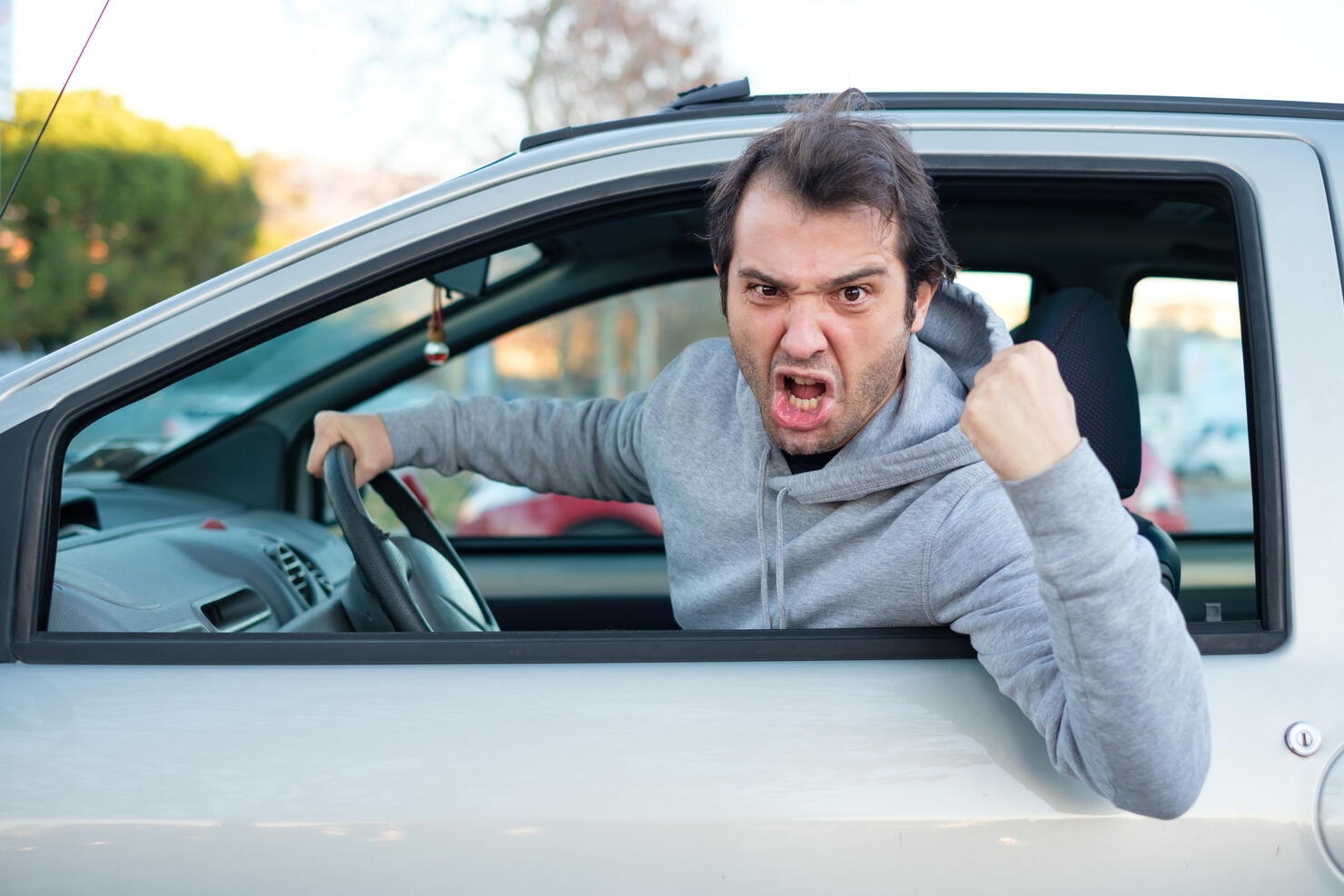 Closeup portrait of aggressive male driver honking in traffic jam